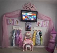 a tv mounted to the side of a wall next to a pink princess doll table