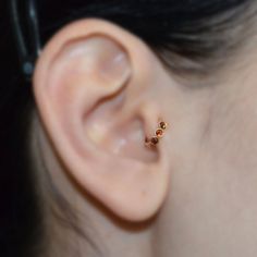 a close up of a person wearing a pair of ear piercings on their ears