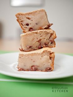 three pieces of cake sitting on top of a white plate next to a green table