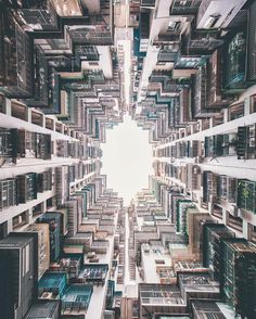 a black and white photo of buildings with lots of windows in the middle, looking up into the sky