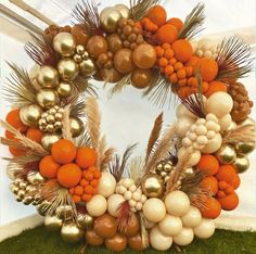 an orange and white wreath with gold ornaments