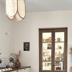 a kitchen with white walls and wooden floors, an old fashioned stove top oven in the center