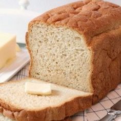 a loaf of bread sitting on top of a table next to butter and a knife