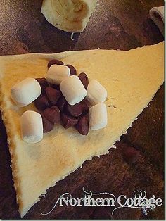 there is a piece of pie with marshmallows on it and the words, bake up some happy s'more croissants