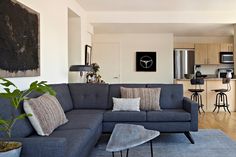 a living room filled with furniture next to a kitchen