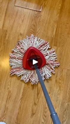 a mop on the floor with a red and white duster next to it