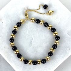 "18k Gold Filled 1mm Box Chain Bracelet Featuring Simulated Onyx Black Bead Ball, Gold Beads, Adjustable Bracelet - Bracelet Size: Thickness: 0.9 mm | Beads Width: 5.8 mm | Length: 9 Inches 💎 With new products daily, quality and competitive prices, in DiJu Jewelry you find the most unique styles of modern designs, always looking for elegance and market trends. *Helping your Jewelry Businesses Grow *Starting your Own Business *Making your Own Collection: DiJu Jewelry ever brings Better Moments f Luxury Classic Black Gold Bracelet, Adjustable Gold Onyx Bracelets, Adjustable Gold Onyx Bracelet, Gold Onyx Jewelry With Black Beads, Black Bracelet With Gold Beads, Adjustable Black Bracelets With Gold Beads, Elegant Black Beaded Bracelet With Adjustable Chain, Elegant Black Beads With Gold Details, Black Beaded Bracelets With Gold Beads For Gifts