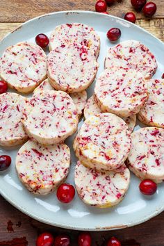 cranberry shortbreads on a plate with fresh cranberries around them