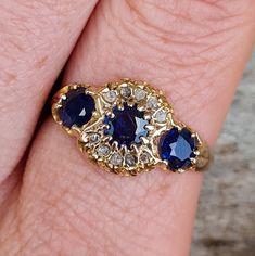 Stunning Antique Edwardian solid 18ct gold Ceylon sapphire diamond trilogy ring in a size S. Detail. Beautiful ring. Solid 18ct gold. Three large old cut natural ink blue Ceylon sapphires. Total sapphire weight of 1.1Ct. The trilogy traditionally represents the past, present and future of a relationship. Central sapphire surrounded by 10 old rough cut natural diamonds. Really unusual design. Flush setting to the diamonds and sapphire with a low profile. Feels lovely to wear. Full English Chester Heirloom Three Stone Sapphire Ring, Heirloom Sapphire Three Stone Ring, Heirloom Sapphire Ring With Three Stones, Vintage Sapphire Three-stone Ring, Vintage Round Three Stone Sapphire Ring, Vintage Round Sapphire Ring With Three Stones, Vintage Three Stone Round Sapphire Ring, Antique Gold Rings Unique, Antique Rings Gold