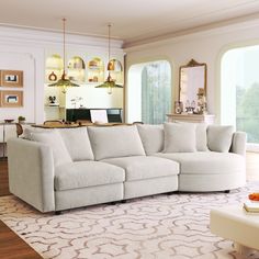 a living room with a large sectional couch in front of an open window and white rug on the floor