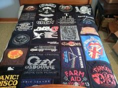 a bed covered in lots of different types of t - shirts