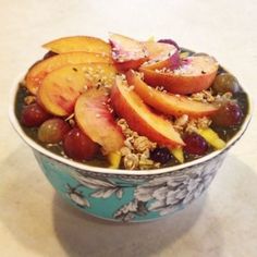 a bowl filled with fruit and granola on top of a table