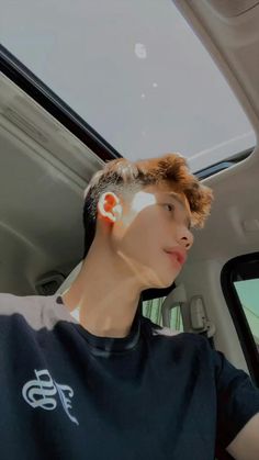 a young man sitting in the back seat of a car with sunburns on his face