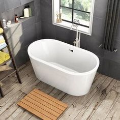 a white bath tub sitting on top of a wooden floor