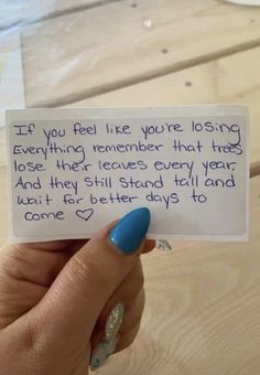 a woman's hand holding up a note that says, if you feel like you're losing everything