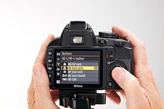 a person holding up a camera to take a photo with it's screen open