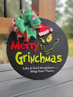 a sign that says merry grinmas like a good neighbor stay over there on the porch