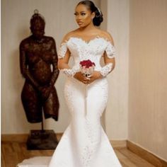 a woman in a wedding dress standing next to a statue