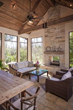 a living room filled with lots of furniture next to a fire place on top of a stone floor