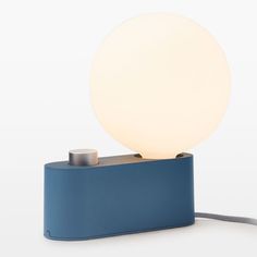 a blue table lamp with a white ball on top and a cord attached to it