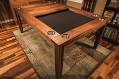 a pool table in the middle of a living room with hardwood floors and wooden furniture