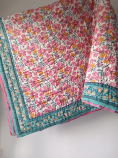 two pink and blue bedspreads with flowers on them