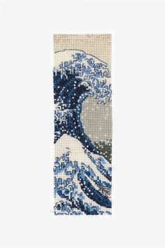 a cross stitch bookmark with the great wave in blue and white colors on it