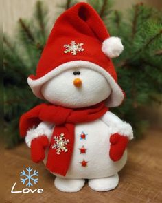 a small stuffed snowman with a red hat and scarf on it's head