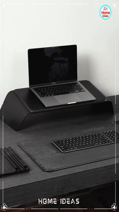 a laptop computer sitting on top of a desk next to a keyboard and mouse pad