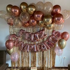 a table topped with lots of balloons and streamers that spell out the word happy new year