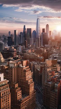 an aerial view of the city at sunset with skyscrapers in the foreground and clouds in the background