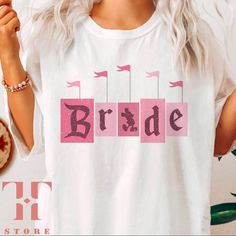 a woman wearing a t - shirt with the word bride printed on it and holding a donut