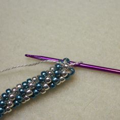 a purple crochet hook with beads on it