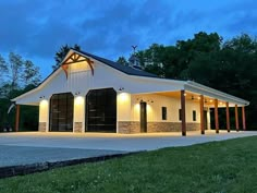 a large white barn with lights on it's roof