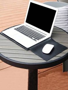 an open laptop computer sitting on top of a wooden table next to a mouse pad