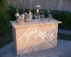 an outdoor bar with wine glasses and ice buckets sitting on it's side