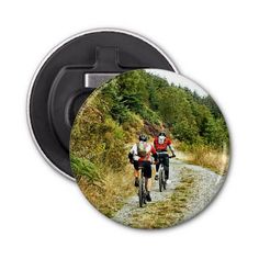 two people riding bikes down a dirt road in the woods pinback button with an image of