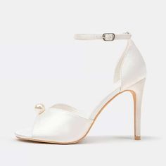 Step into sophistication with these satin peep toe pearl embellished heeled sandals in white. These sandals elevate your style effortlessly with a delicate ankle strap and elegant pearls. Color: White Material: Satin Heel Type: Stiletto heel Heel Height: 3.35" / 85 mm approx Product measurements were taken using size 8. Please note that measurements may vary by size. Toe: Peep toe Pearl embellished design Adjustable buckled ankle strap design Handcrafted US sizing. Fits true to size. Pearl Open Toe Wedding Shoes For Formal Occasions, White Pearl Open Toe Heels, Formal Open Toe Pearl Wedding Shoes, Formal Pearl Open Toe Wedding Shoes, Pearl Open Toe Heels For Evening, Elegant Pearl-embellished Open Toe Sandals, Chic Pearl Embellished Ankle Strap Wedding Shoes, Elegant Pearl Sandals For Party, Elegant Party Heels With Pearl Handle