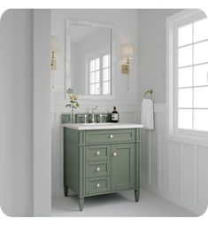 a bathroom with green cabinets and white walls