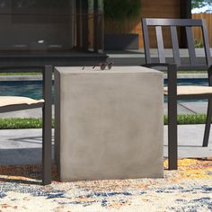 two chairs sitting next to each other in front of a pool