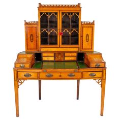 an old wooden desk with glass doors and drawers