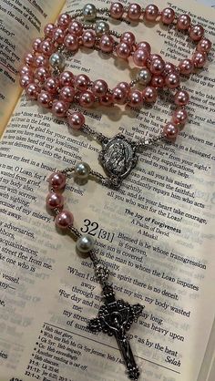 the rosary is laying on top of an open book