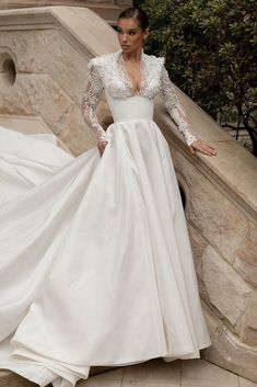 a woman in a wedding dress standing on some steps