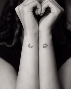 two small wrist tattoos with the sun and moon on each one side of their arms