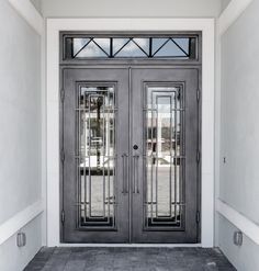 two double doors with glass panels on the front of a house in gray and white