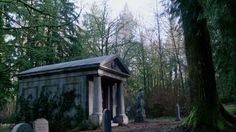 an old cemetery in the middle of a forest with tombstones and trees around it