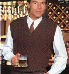 a man in a vest and tie holding a beer