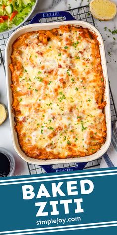 baked ziti in a casserole dish next to salad