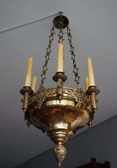 a chandelier hanging from the ceiling with four candles in it's center