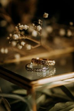 two wedding rings sitting on top of a table